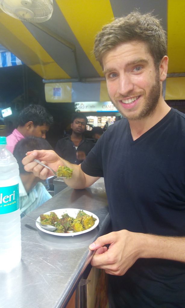 India_Mumbai eating aloo saag at street counter